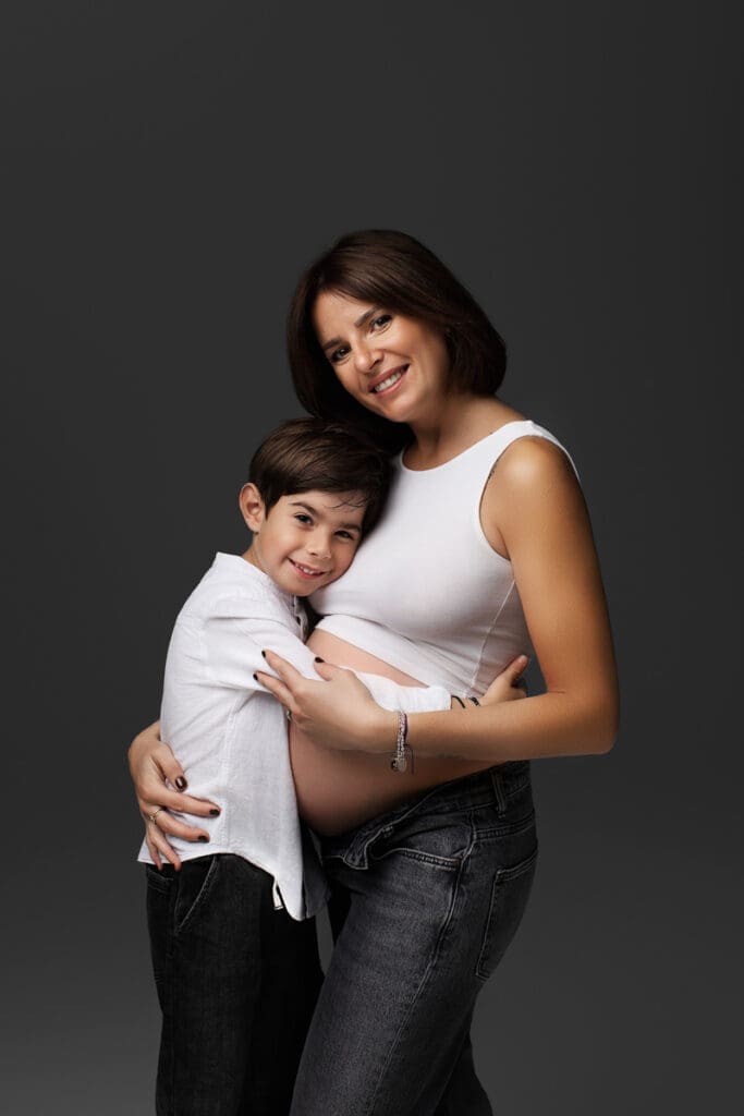 portrait grossesse avec futur grand frère câlin avec sa maman en studio