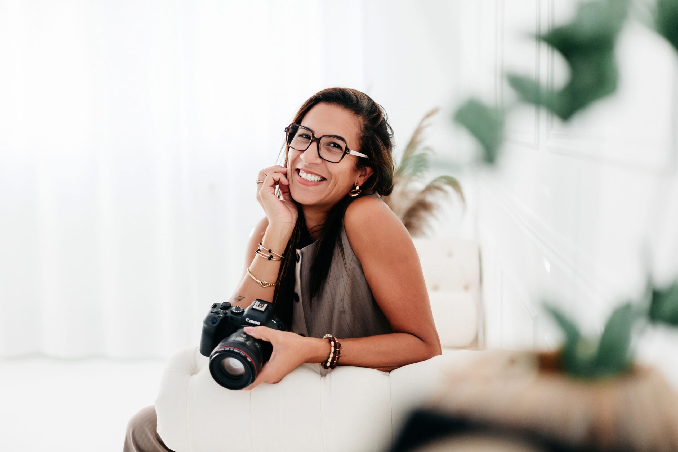 photographe magali tinti souriante qui tient son appareil photo dans son studio