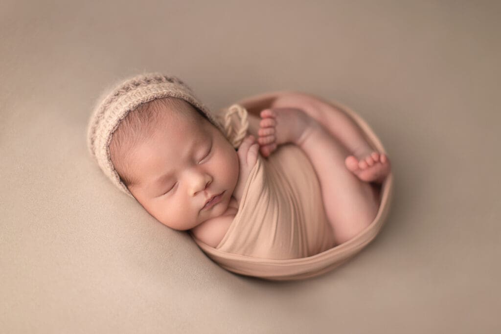 bébé emmailloté dans un petit bol – photographie naissance douce en studio à Lognes