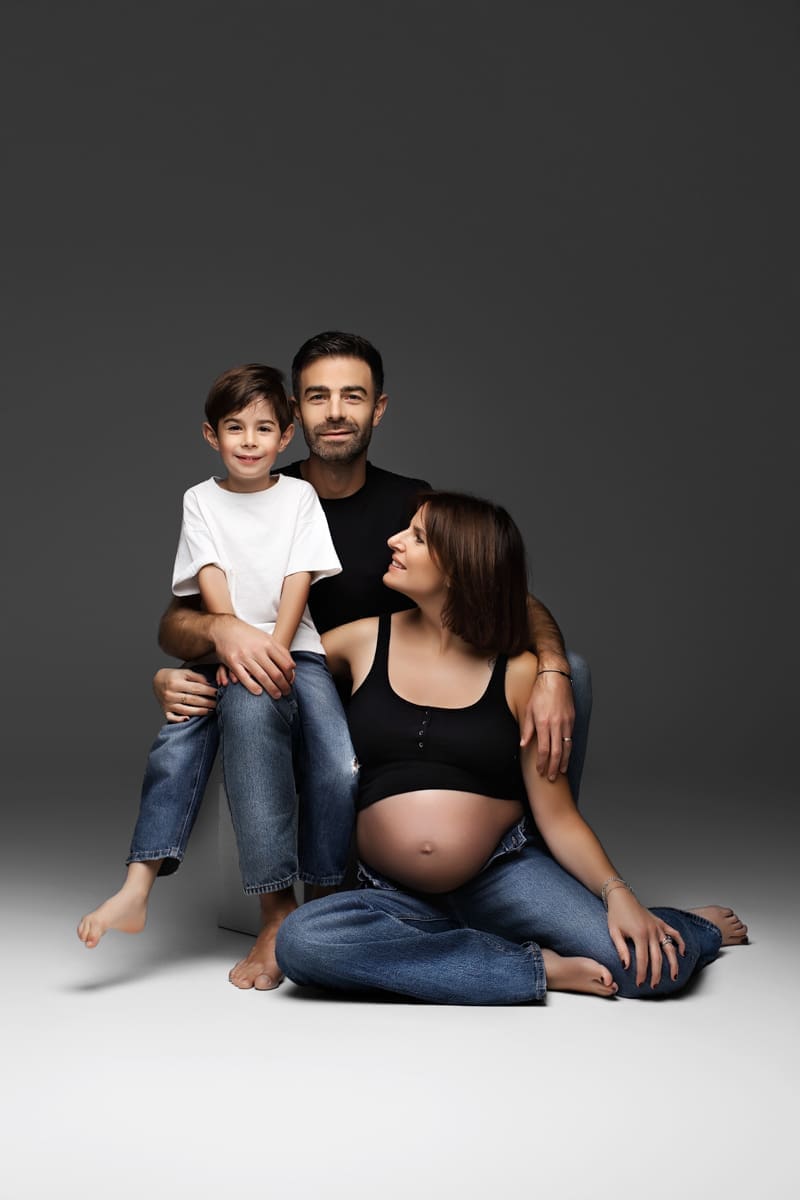 Future maman photographiée avec sa famille au studio